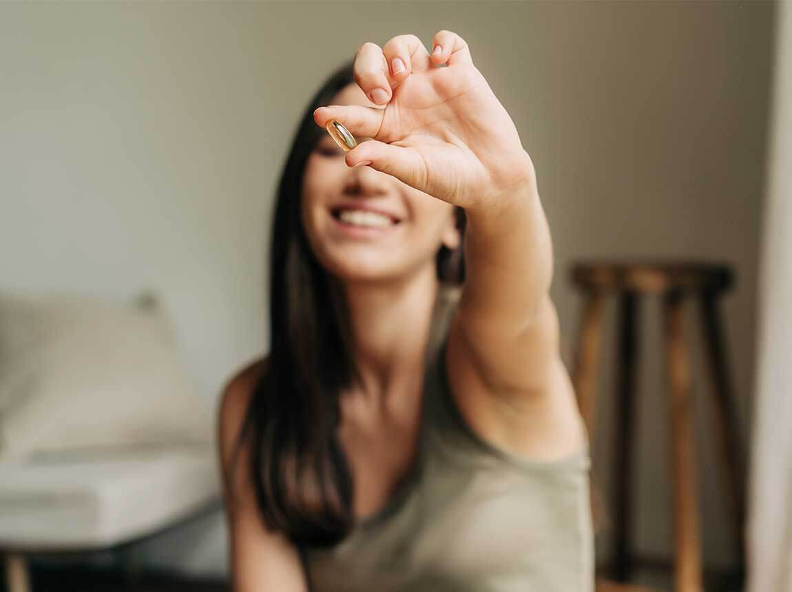 žena s omega-3 kapsulom