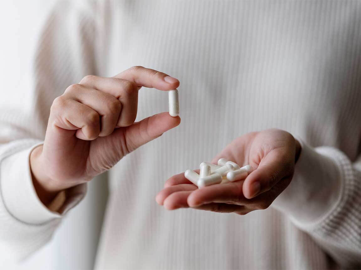 žena s kapsulama vitamina i minerala